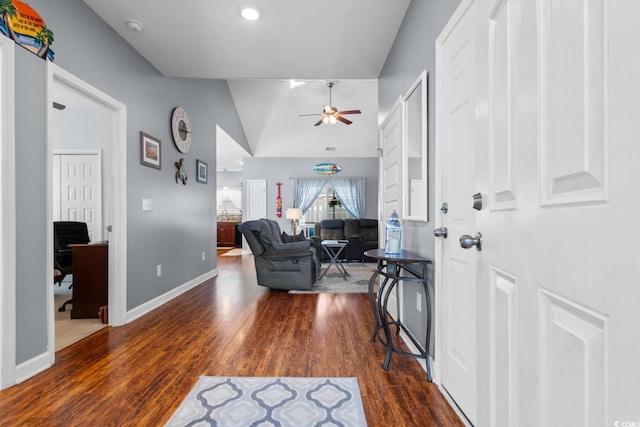 entryway with lofted ceiling, ceiling fan, baseboards, and wood finished floors