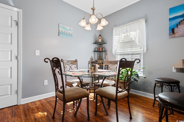 dining space with baseboards, a chandelier, and wood finished floors