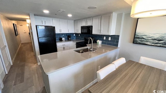 kitchen with sink, tasteful backsplash, black appliances, white cabinets, and kitchen peninsula