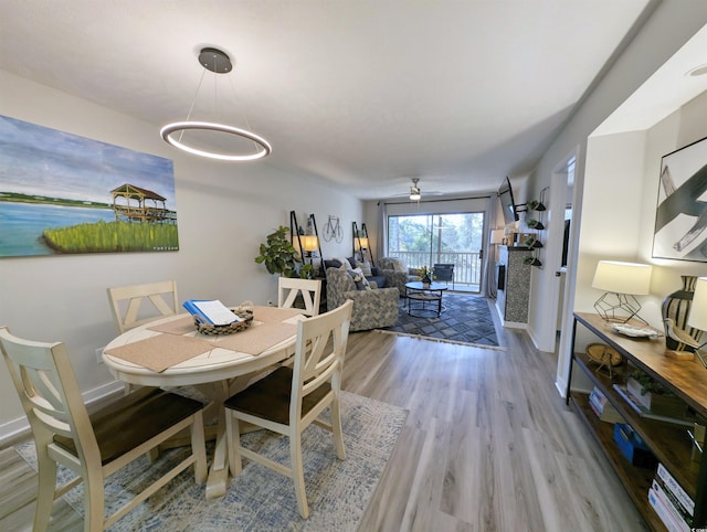 dining area with light hardwood / wood-style floors and ceiling fan