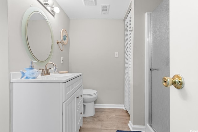 bathroom with vanity, wood-type flooring, and toilet