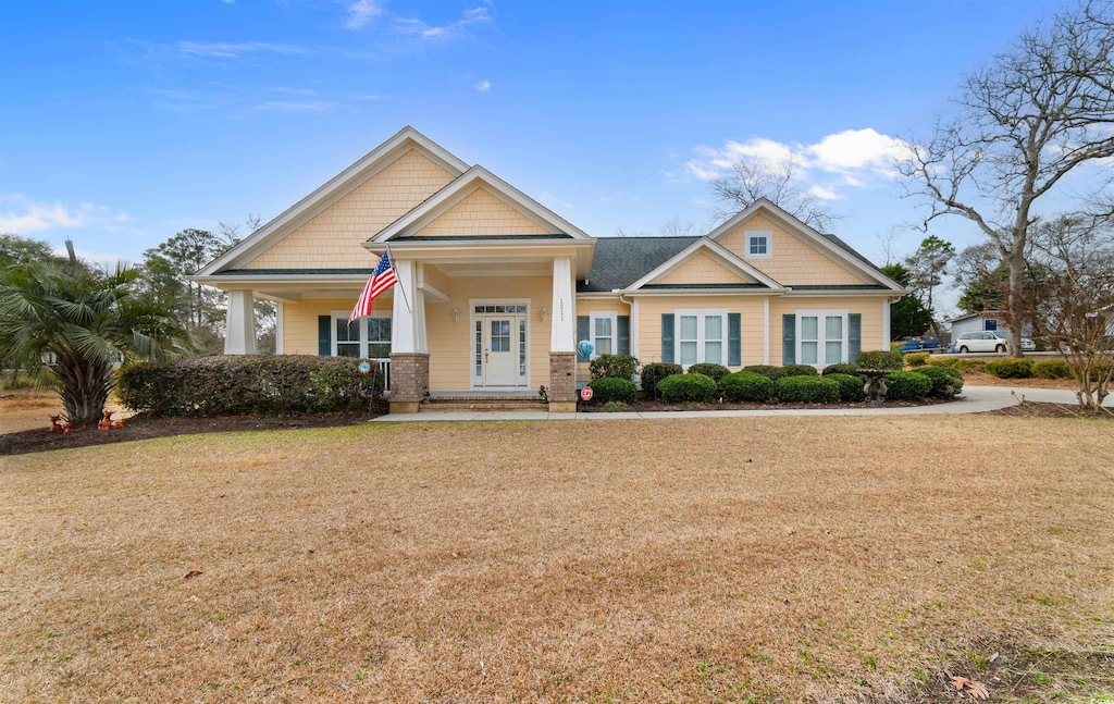 craftsman house with a front lawn and a porch