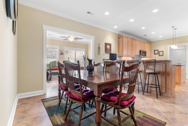 dining area with light tile patterned floors, ornamental molding, and ceiling fan