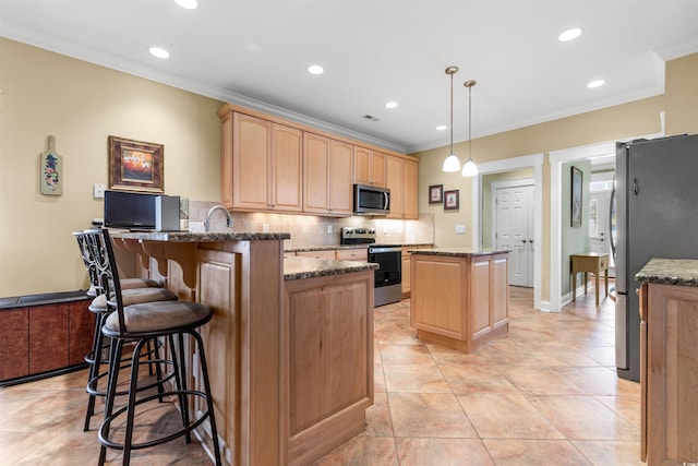 kitchen featuring appliances with stainless steel finishes, pendant lighting, dark stone countertops, backsplash, and kitchen peninsula