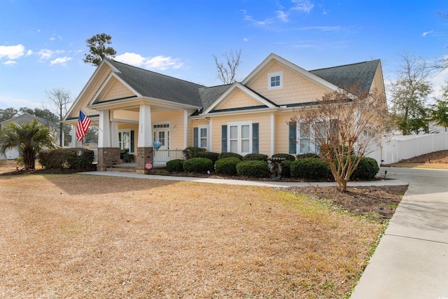 craftsman inspired home with covered porch and a front lawn