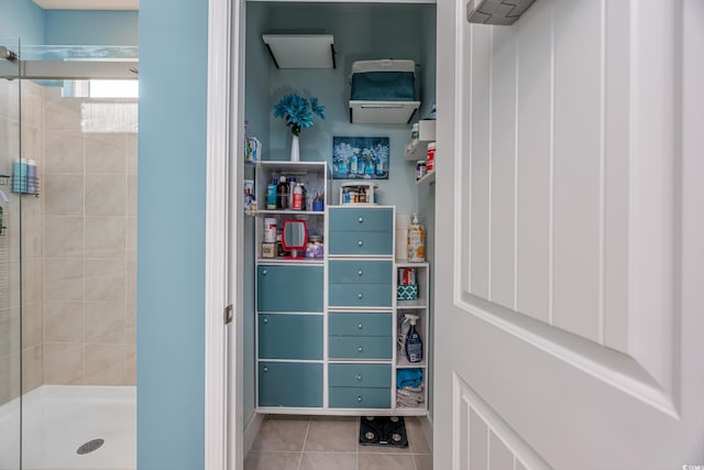 bathroom with tiled shower and tile patterned floors