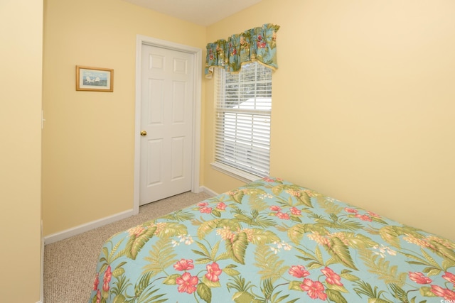 bedroom featuring baseboards and light colored carpet