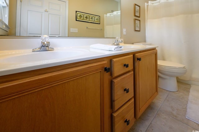 bathroom with tile patterned floors, a sink, toilet, and double vanity