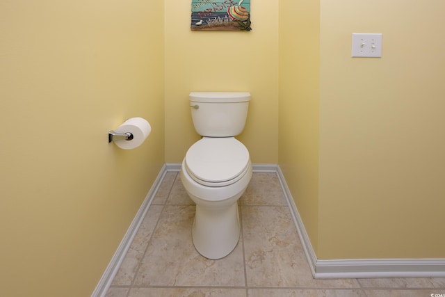 bathroom with tile patterned flooring, toilet, and baseboards