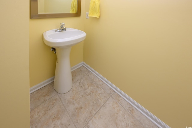 bathroom with a sink and baseboards