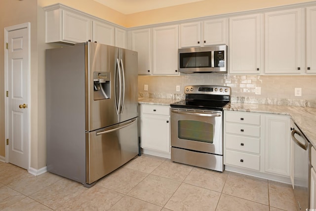 kitchen featuring stainless steel appliances, tasteful backsplash, white cabinetry, and light stone countertops