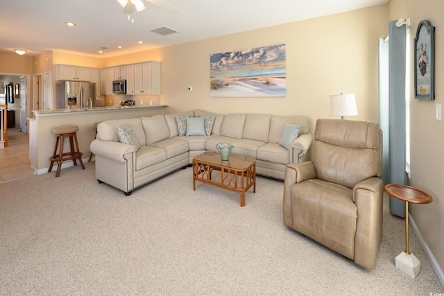 living area with recessed lighting, light colored carpet, and baseboards