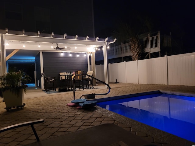 pool at night with a fenced in pool, a pergola, fence, and a patio