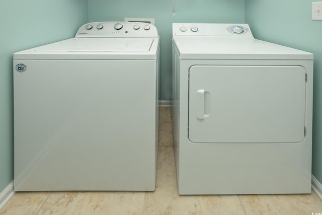 laundry area featuring laundry area, washing machine and clothes dryer, and baseboards