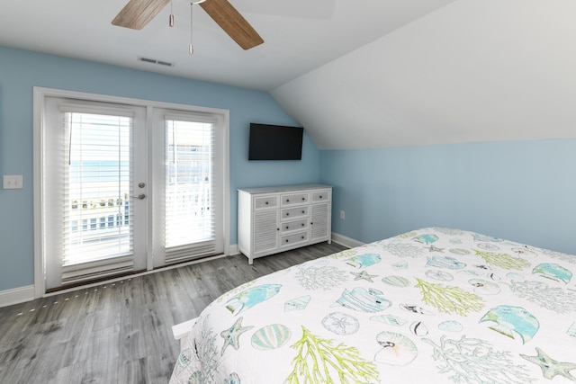 bedroom featuring hardwood / wood-style flooring, ceiling fan, access to exterior, and vaulted ceiling