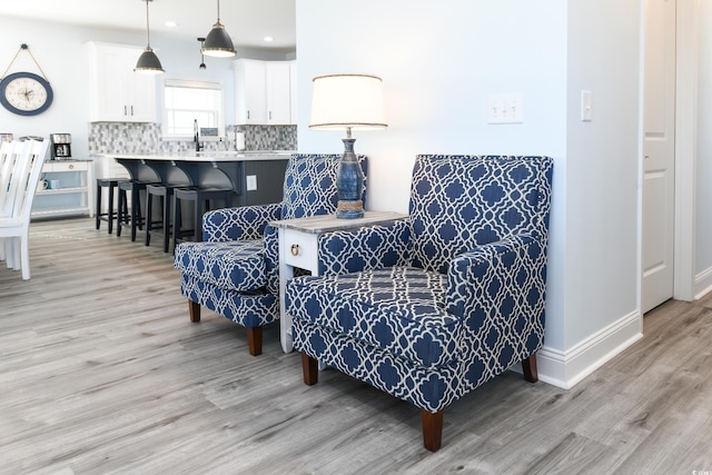 sitting room featuring sink and light hardwood / wood-style flooring