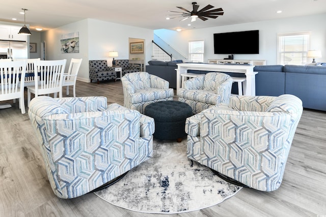 living room featuring ceiling fan and light hardwood / wood-style flooring