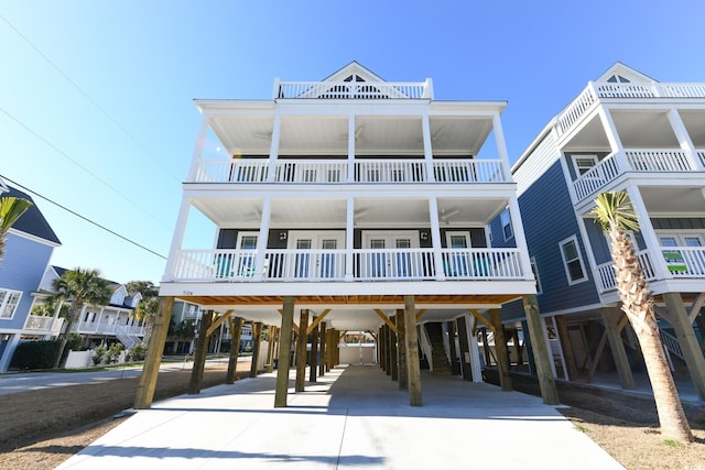 raised beach house featuring a carport and a balcony