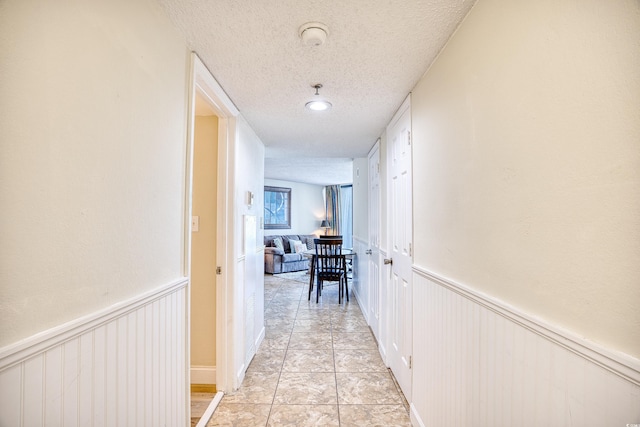 hall featuring a textured ceiling