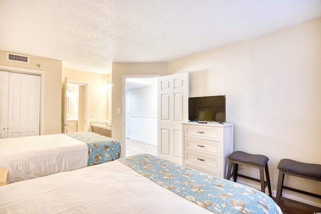 bedroom featuring a closet, a textured ceiling, and ensuite bathroom