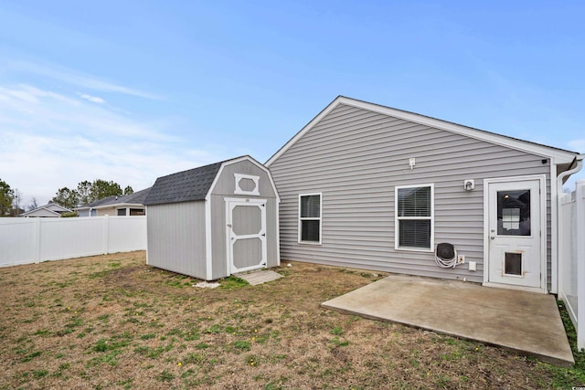 rear view of property featuring a storage shed, a lawn, and a patio