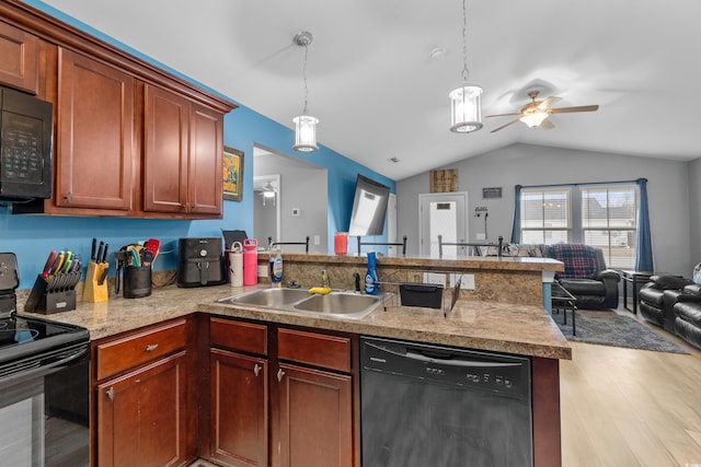 kitchen featuring sink, hanging light fixtures, light hardwood / wood-style floors, black appliances, and vaulted ceiling