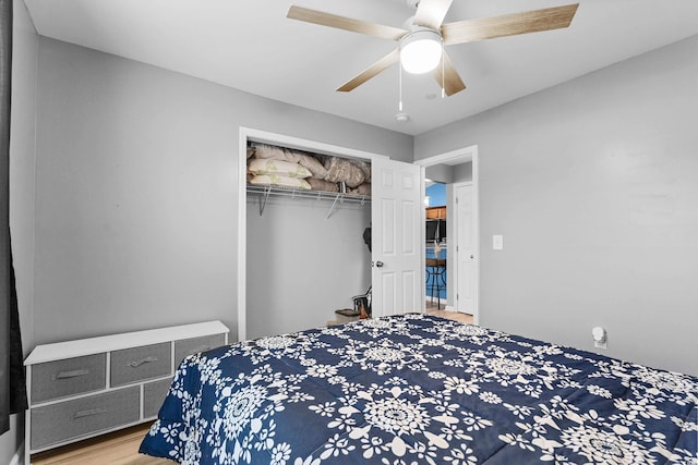 bedroom featuring hardwood / wood-style flooring, ceiling fan, and a closet