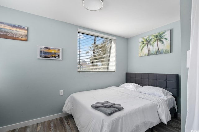 bedroom with dark hardwood / wood-style flooring