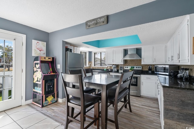 dining space with a textured ceiling and light hardwood / wood-style floors