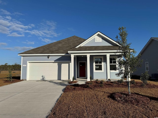 view of front of property with driveway, central AC unit, roof with shingles, and an attached garage