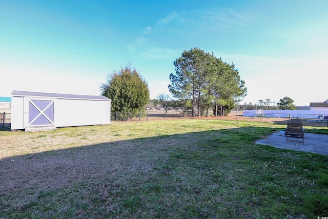 view of yard with a storage unit, fence, and an outbuilding