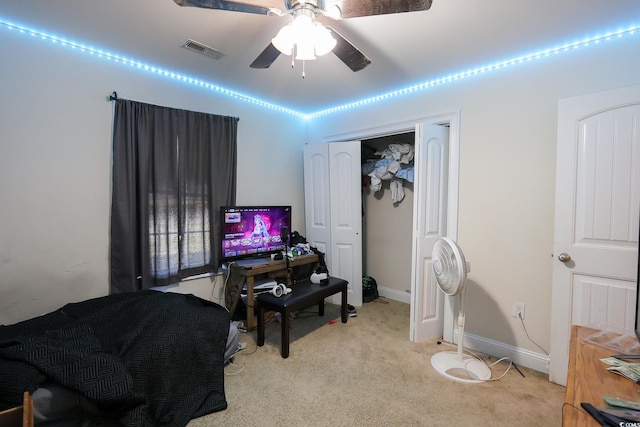 bedroom with ceiling fan, light colored carpet, visible vents, baseboards, and a closet