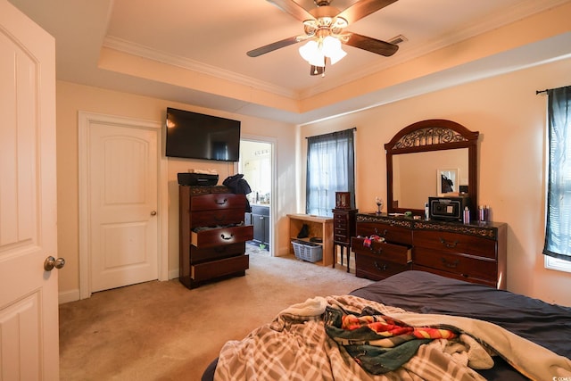 bedroom featuring crown molding, a raised ceiling, light colored carpet, visible vents, and ceiling fan