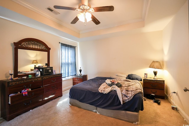 bedroom featuring visible vents, a raised ceiling, crown molding, and light colored carpet