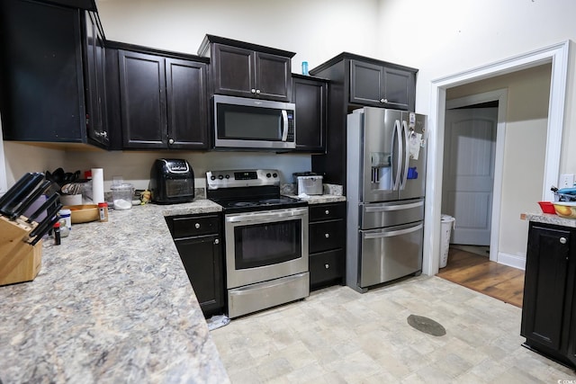 kitchen featuring appliances with stainless steel finishes and dark cabinets