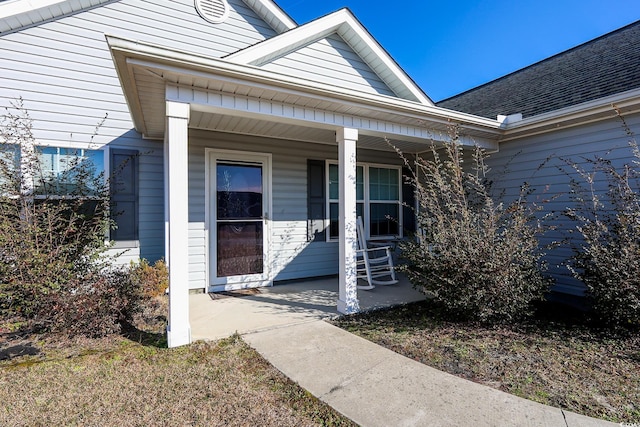 property entrance featuring a porch and a shingled roof