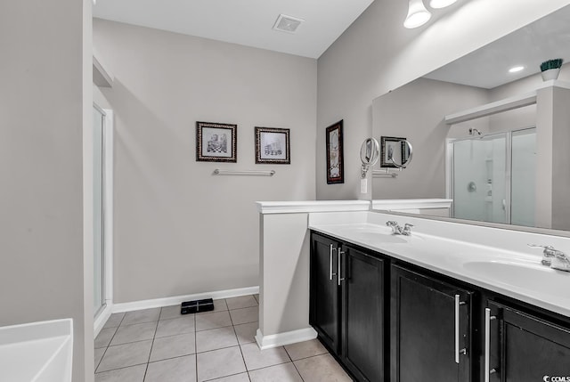 bathroom featuring tile patterned flooring, vanity, and a shower with door