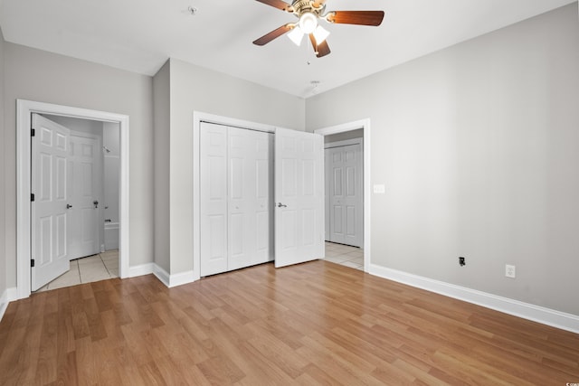 unfurnished bedroom featuring a closet, ensuite bathroom, light wood-style floors, ceiling fan, and baseboards