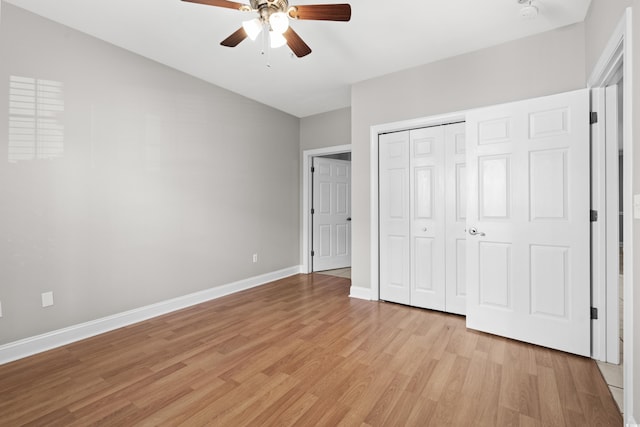 unfurnished bedroom featuring light wood-style floors, a closet, ceiling fan, and baseboards