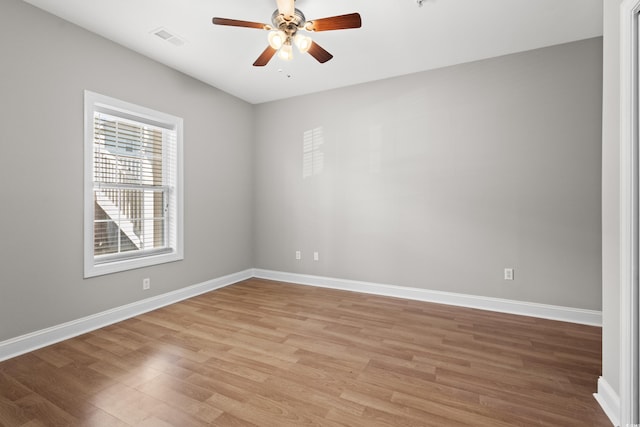 unfurnished room with light wood-style floors, visible vents, baseboards, and ceiling fan