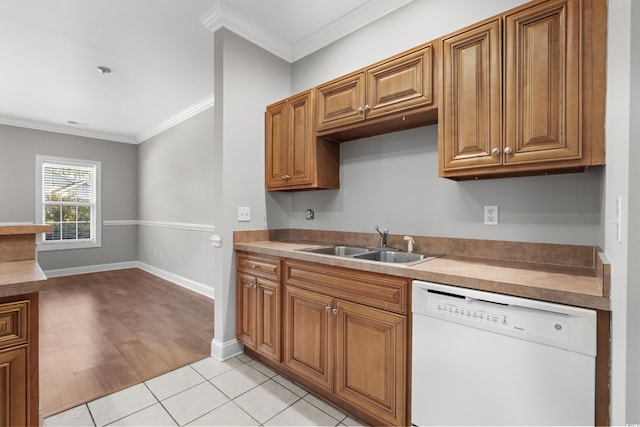 kitchen with dishwasher, ornamental molding, a sink, and brown cabinets