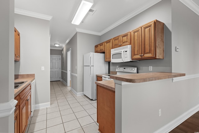 kitchen with white appliances, light tile patterned floors, ornamental molding, brown cabinets, and a peninsula