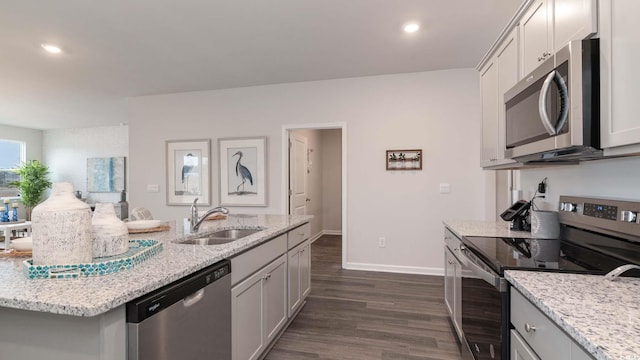 kitchen with light stone counters, sink, dark hardwood / wood-style floors, and appliances with stainless steel finishes