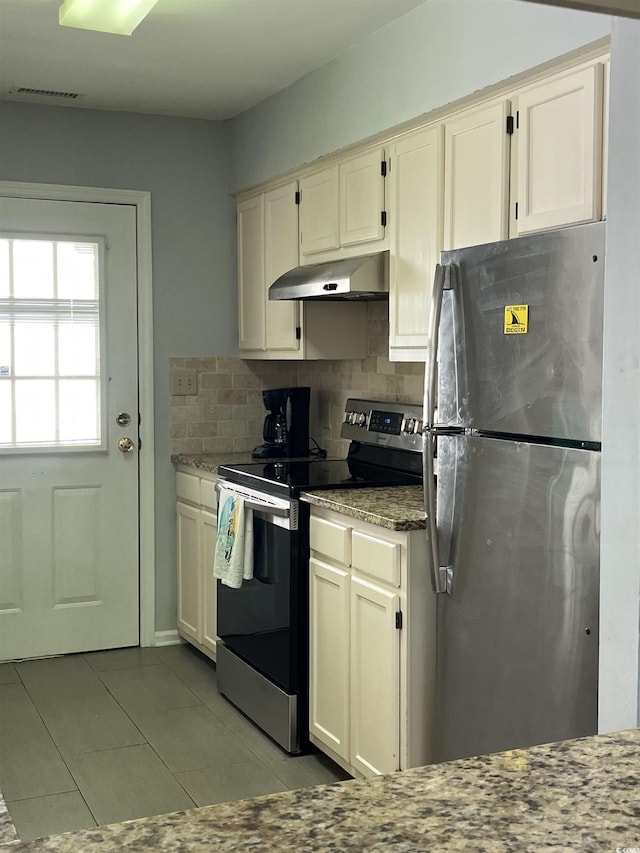 kitchen with light stone counters, appliances with stainless steel finishes, and backsplash