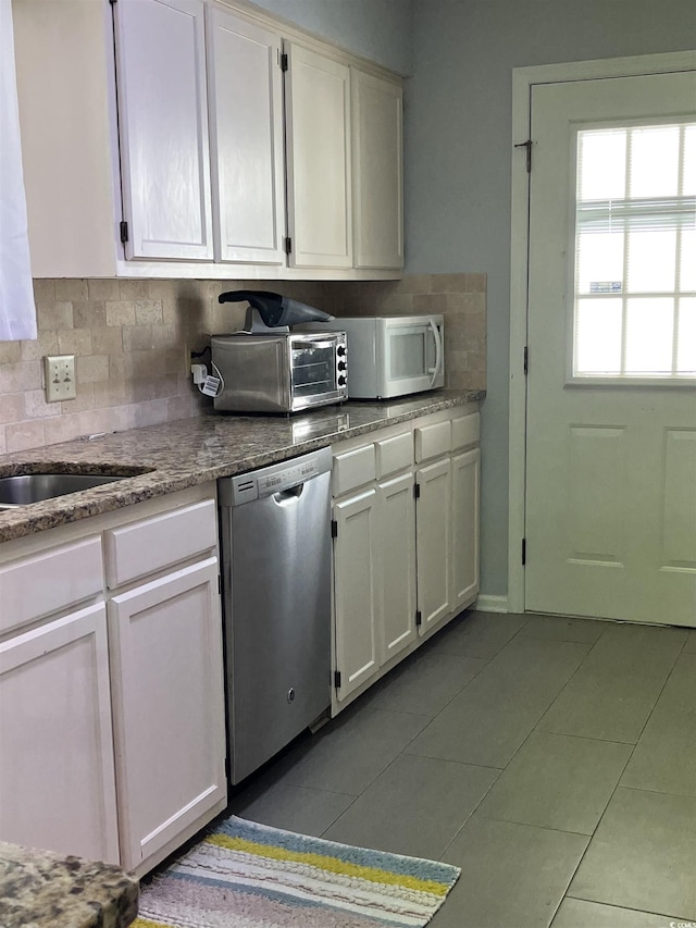 kitchen featuring white cabinets, backsplash, dishwasher, and light tile patterned flooring