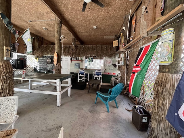 miscellaneous room featuring concrete floors, ceiling fan, and a workshop area