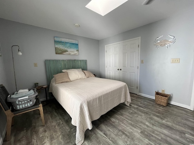 bedroom featuring dark hardwood / wood-style flooring, a skylight, and a closet