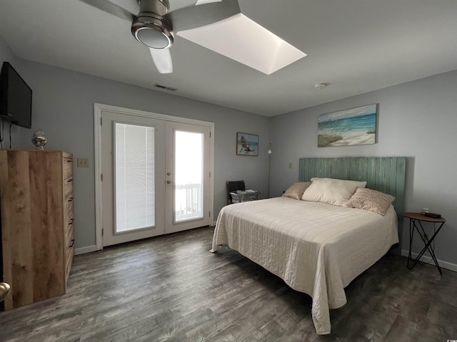 bedroom featuring a skylight, dark wood-type flooring, access to outside, and french doors