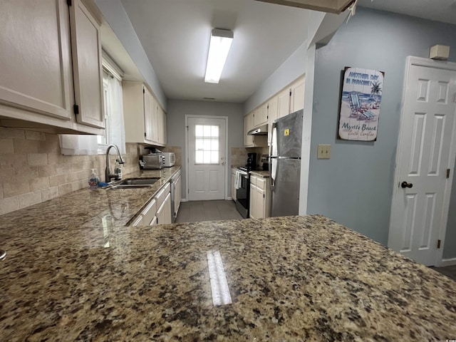 kitchen featuring sink, backsplash, light stone countertops, and appliances with stainless steel finishes