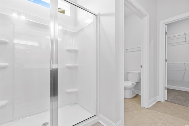 bathroom featuring toilet, tile patterned floors, and walk in shower